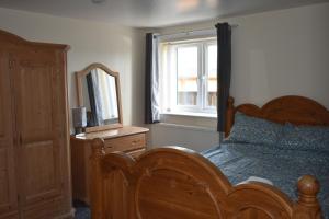 a bedroom with a bed and a mirror and a dresser at 4 Woodyard Cottages, 2 Bedroom with free parking. in Long Sutton