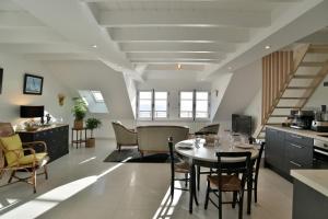cocina y comedor con mesa y sillas en LOstra 2 - Appartement avec mezzanine, en Cancale