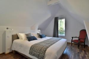 una camera con un grande letto e una sedia rossa di LOstra 2 - Appartement avec mezzanine a Cancale