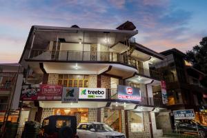 un edificio con coches estacionados frente a él en Treebo Trend Akashdeep, en Dharamshala