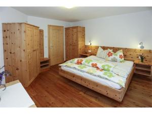 um quarto com uma cama grande, pisos em madeira e armários em madeira em Bio Kräuterhof Oberpalwitter em Barbiano