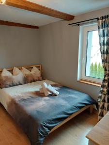 a bed in a room with a window at Madekszówka -pokoje gościnne in Ściegny