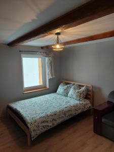 a bedroom with a bed and a window at Madekszówka -pokoje gościnne in Ściegny