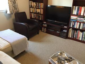 een woonkamer met een stoel en een televisie bij Comelybank Guesthouse in Crieff