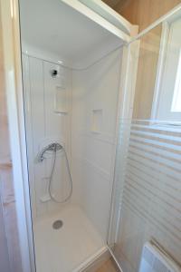 a white shower with a glass enclosure in a bathroom at Camping Municipal Le Tindio in Arzon