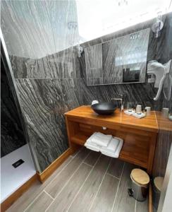 y baño con lavabo de madera y ducha. en Logis Hôtel & Restaurant - Le Mouton Blanc, en Cambrai