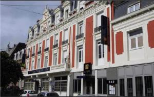 une rangée de grands bâtiments dans une rue de la ville dans l'établissement Logis Hôtel & Restaurant - Le Mouton Blanc, à Cambrai