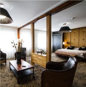 カンブレーにあるLogis Hôtel & Restaurant - Le Mouton Blancのベッドとテーブルが備わるホテルルームです。