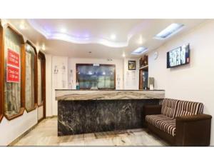 vestíbulo con bar con sofá y TV en Hotel Ashoka Inn, Kanpur, en Kānpur