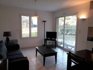un soggiorno con un divano, una TV e un tavolo di Studio dans une résidence calme - 9544 a Soulac-sur-Mer Altre 11 foto