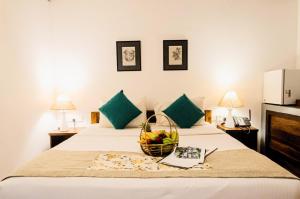 a hotel room with a basket of fruit on a bed at Pinthaliya Resort in Sigiriya