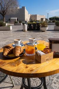 una mesa de madera con una bandeja de pan y bebidas en Duomo Guest House, en Barletta