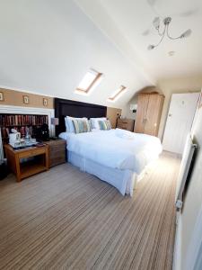 1 dormitorio con 1 cama blanca grande y escritorio en Cleave Court Guest House, en Llandudno