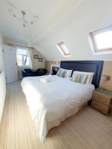 a large white bed in a room with windows at Cleave Court Guest House in Llandudno