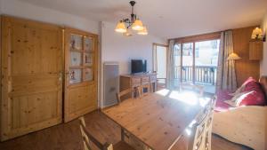 Pokój z drewnianym stołem i jadalnią w obiekcie B305- Appartement 2 pieces cabine 6 personnes w mieście Orcières