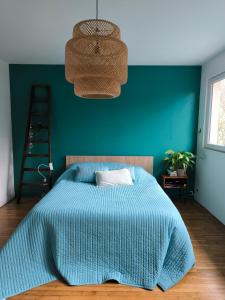 ein Schlafzimmer mit einem Bett und einer grünen Wand in der Unterkunft Chambre d'hôte proche de la nature in Lamorlaye