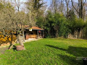 un jardín con una casa con un árbol en el patio en Chambre d'hôte proche de la nature, en Lamorlaye