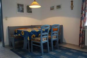 a dining room table with two chairs and a table with a blue table cloth at Ferienhaus Hylla Fischerstraße in Carolinensiel