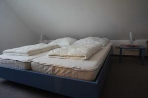 two unmade beds in a room with a table at Ferienhaus Hylla Fischerstraße in Carolinensiel