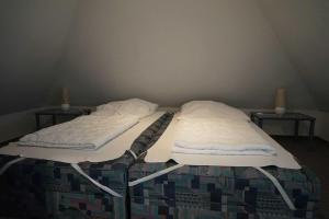 two twin beds in a room with two tables at Ferienhaus Hylla Fischerstraße in Carolinensiel +3 photos