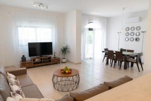 uma sala de estar com um sofá e uma mesa em Oceans Breeze Villa em Protaras
