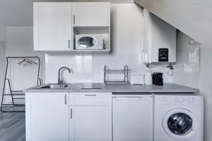 een witte keuken met een wastafel en een wasmachine bij 804 Suite Styling - Superbe Duplex in Bagnolet