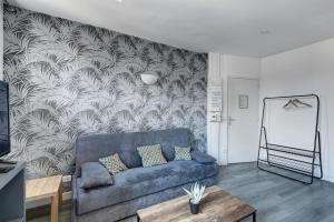 - un salon avec un canapé bleu et un mur dans l'établissement 804 Suite Styling - Superbe Duplex, à Bagnolet