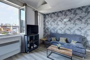 - un salon avec un canapé bleu et une fenêtre dans l'établissement 804 Suite Styling - Superbe Duplex, à Bagnolet