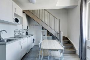 een keuken met een tafel met stoelen en een trap bij 804 Suite Styling - Superbe Duplex in Bagnolet