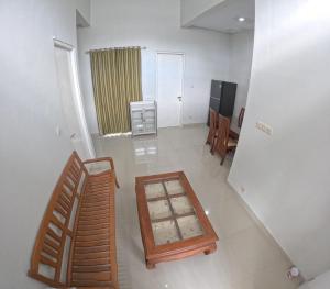 a living room with a table and chairs and a television at GKR J8 Homestay Jogja in Pedes