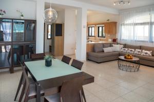 uma cozinha e sala de estar com uma mesa e um sofá em Oceans Breeze Villa em Protaras