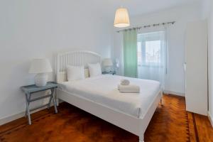 セトゥーバルにあるPatios das Marias, Apartamento T3, Rosasのベッドルーム1室(白いベッド1台、テーブル、窓付)