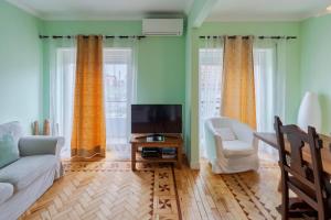 a living room with a couch and a tv at Pátios das Marias - Rosas in Setúbal +33 photos
