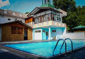 a house with a swimming pool in front of a house at Green View Holiday Resort in Kandy