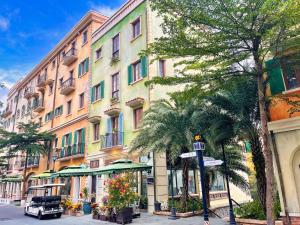 a building on the side of a street with palm trees at Cybele Sunset Hotel Phu Quoc in Phu Quoc