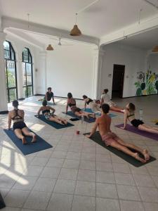 un gruppo di persone sedute a lezione di yoga di Hummus Hostel & Restaurant a Hikkaduwa