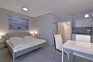 1 dormitorio con cama, mesa y cocina en RES 408 - Residenz - Teilseeblick en Scharbeutz