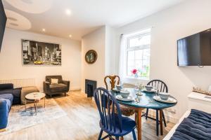 uma sala de estar com uma mesa e um sofá em 1 Phoenix Cottages, 403 High Street, Cheltenham em Cheltenham