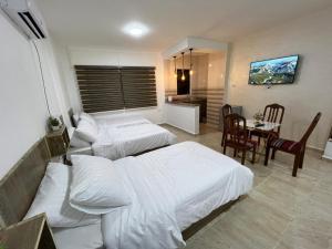 a bedroom with two beds and a table and a dining room at The guset house in Kerak