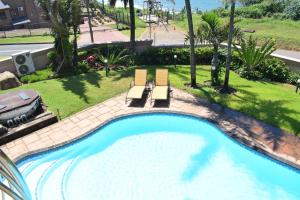 an overhead view of a swimming pool with two chairs at 134 On Ocean View in Amanzimtoti