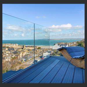 a balcony with a view of a city and the ocean at Uno St Ives - Luxury Serviced Accommodation in St Ives