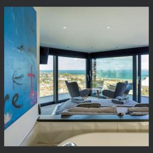 a room with a large window with chairs and a bed at Uno St Ives - Luxury Serviced Accommodation in St Ives