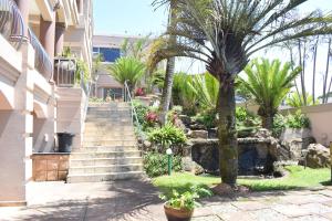 a stairway leading up to a building with palm trees at 134 On Ocean View in Amanzimtoti