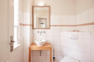 La salle de bains est pourvue d'un lavabo, de toilettes et d'un miroir. dans l'établissement Haus Parkstrasse, à Wyk auf Föhr