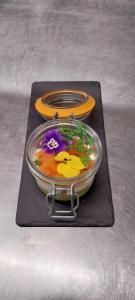 a glass bowl with flowers in it on a black tray at L'Aquitaine - Cahors Sud in LʼHospitalet