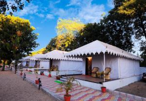 a row of white tents in a park at Jawai Nature Stay - Leopard Safari Camp Jawai Bandh in Bīsalpur