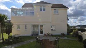 a house with a table and chairs in the yard at Chymoresk - Self Catering Holiday Cottage Hayle St Ives Bay in Hayle