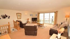 a living room with a couch and a tv at Chymoresk - Self Catering Holiday Cottage Hayle St Ives Bay in Hayle