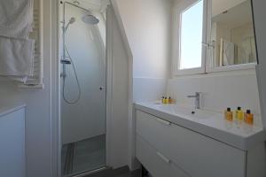 a white bathroom with a sink and a shower at Rooftop Invalides in Paris
