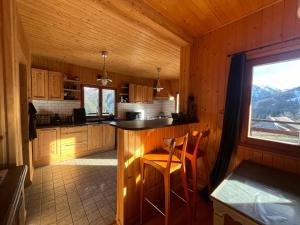 a kitchen with a counter and a window in a cabin at Chalet l'Aigle bleu in Uvernet
